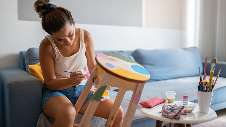 woman painting stool