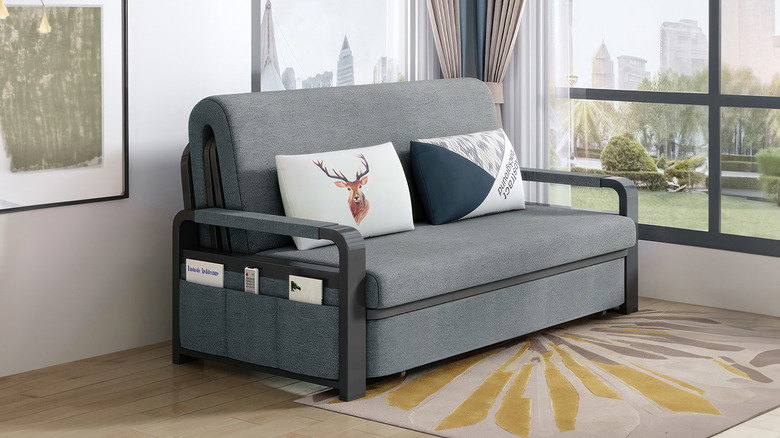 Folded gray sofa bed with pillows