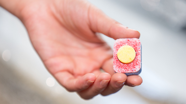 hand holds dishwashing tablet