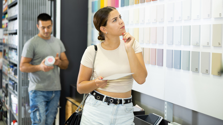 Man and woman browse hardware store paint section