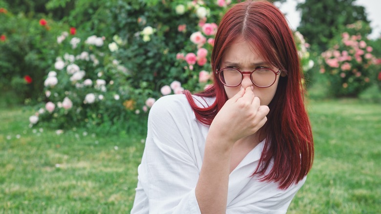 woman holding nose