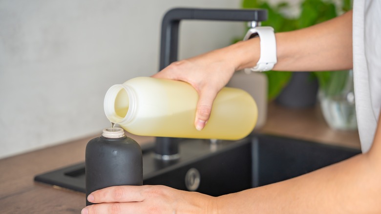 Pouring soap into hand dispenser