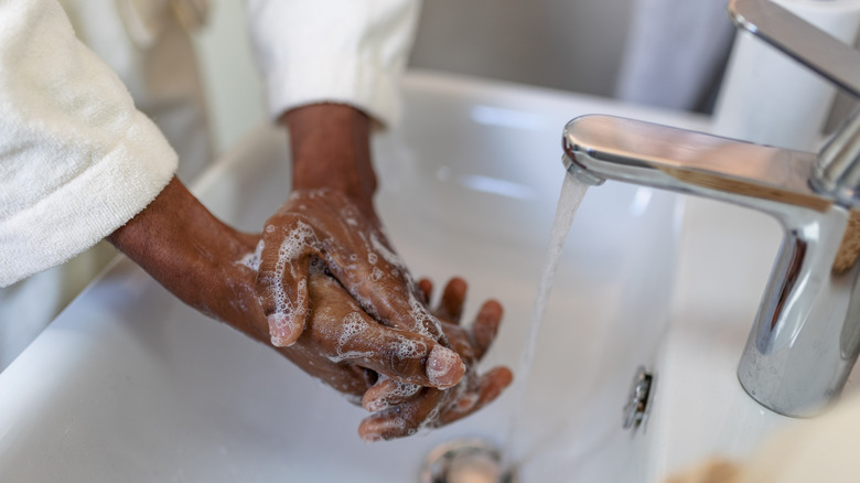 Person washing hands in sink