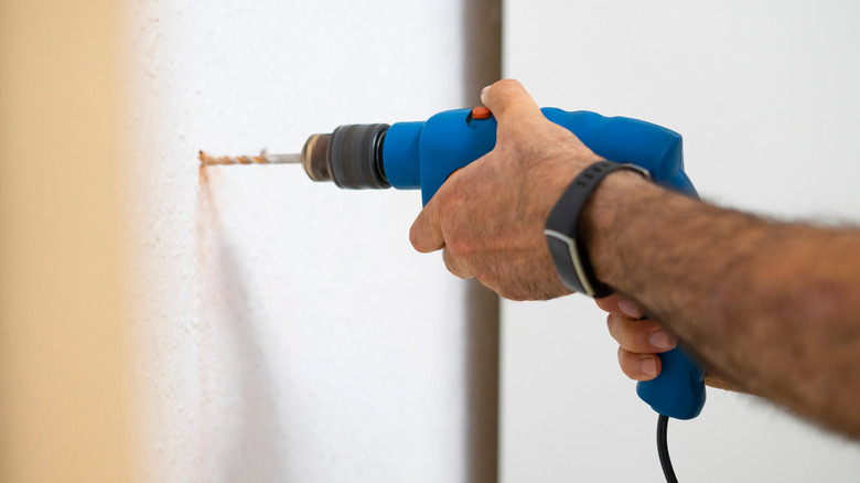 carpenter drilling into wall