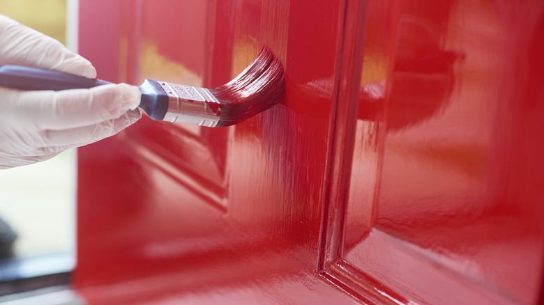 hand painting a door red