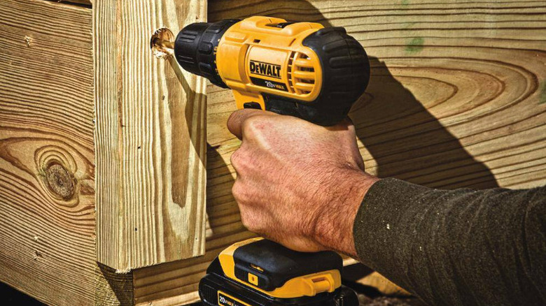 Man using DeWalt 20V cordless drill on wood