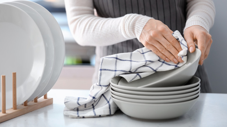 Person drying plate, dish towel 