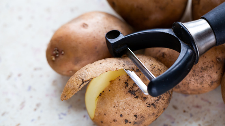 Vegetable peeler peeling potato