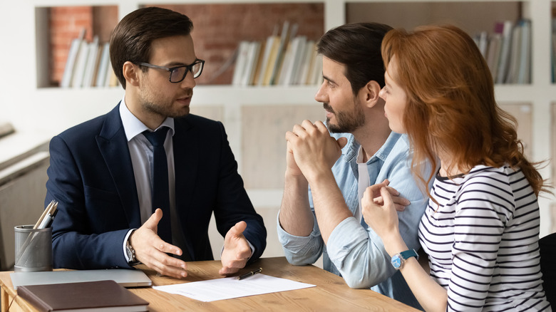 Couple talking with financial adviser