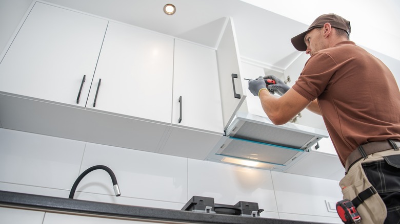 Man installing cabinet handles