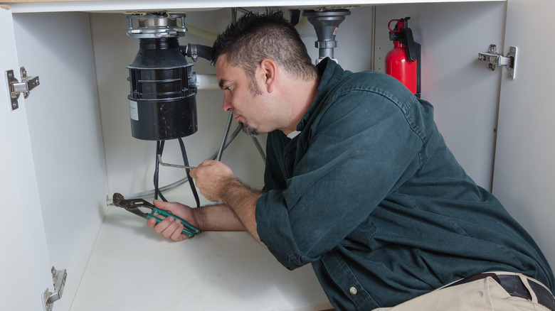 man fixing garbage disposal