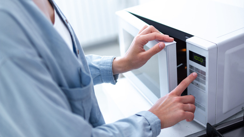 person using a microwave