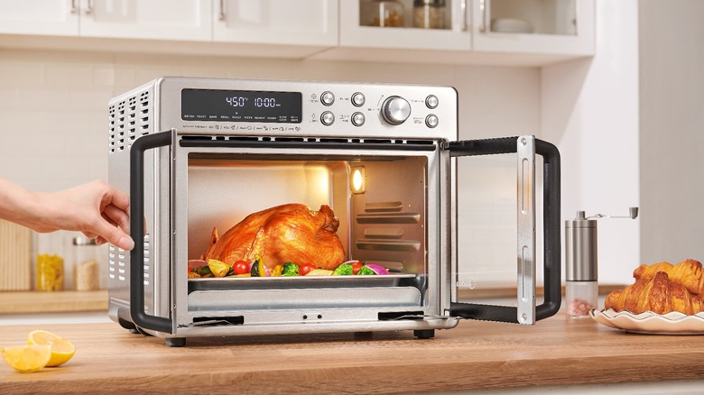 The Midea Flexify French Door Air Fryer Oven with grilled chicken and veggies in it