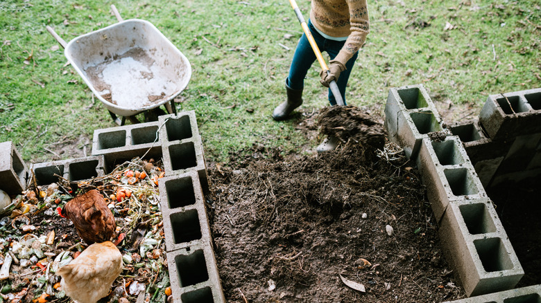 person turning compost heap