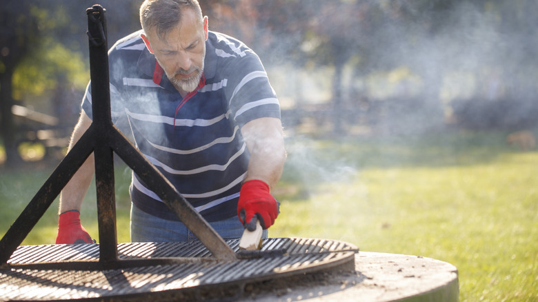 Person cleaning steaming grill