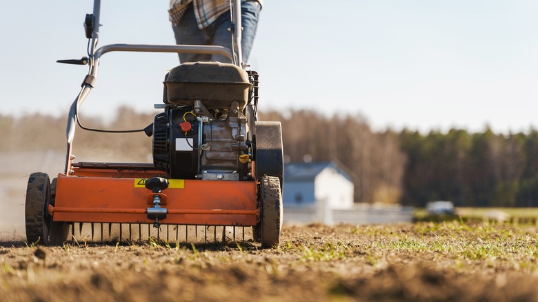 Person using powered aerator machine