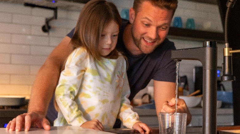 father and daughter filling water cup