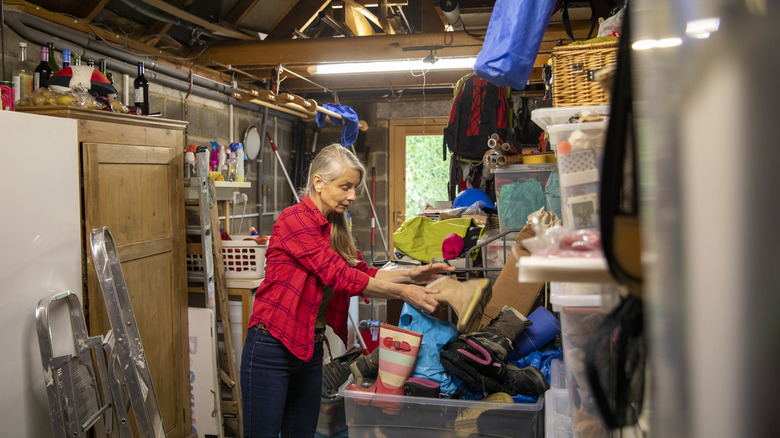 Woman sorts a messy garage