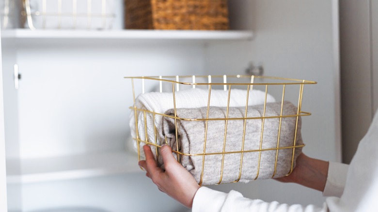 person placing basket in closet