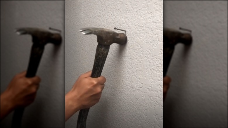 Hammer, nail, and white wall