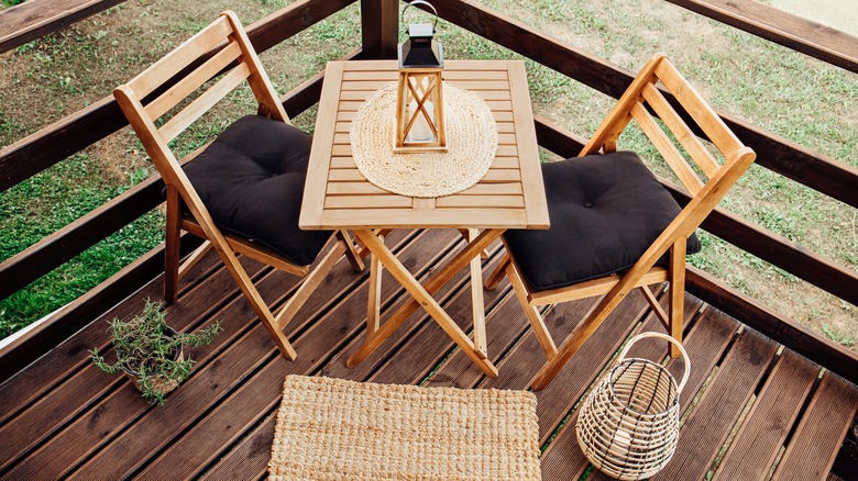 wooden bistro set on patio with boho decor