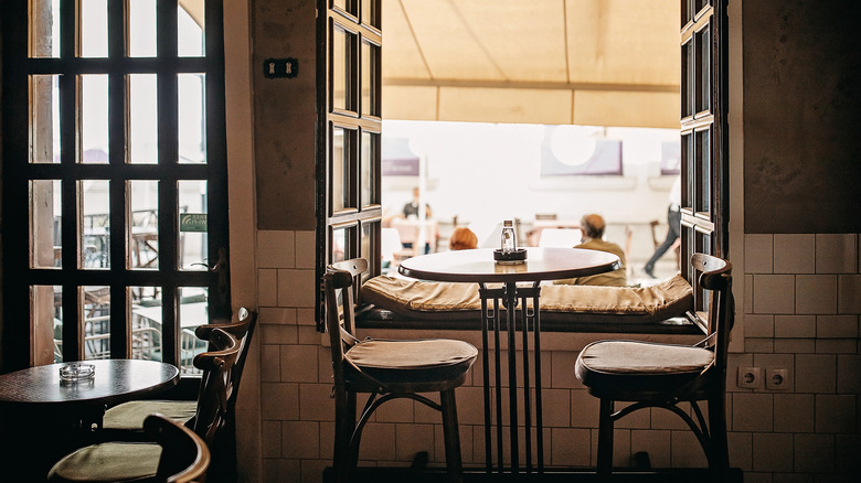 Table and chairs by window in French bistro