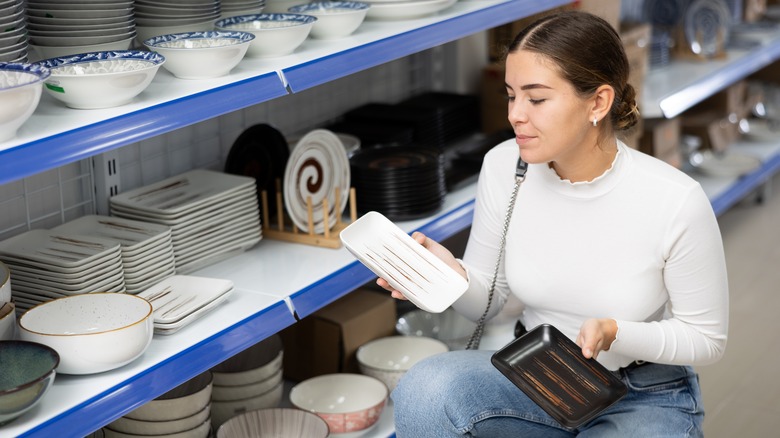 A woman looking at plates in a thrift shop