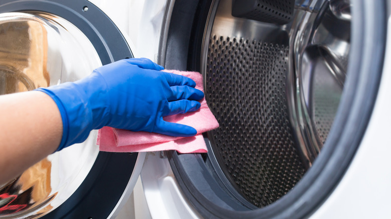 Person wiping washer drum