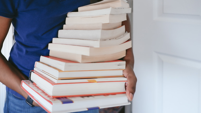 Person holding stack of books