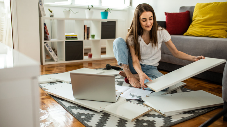 girl assembling furniture at home