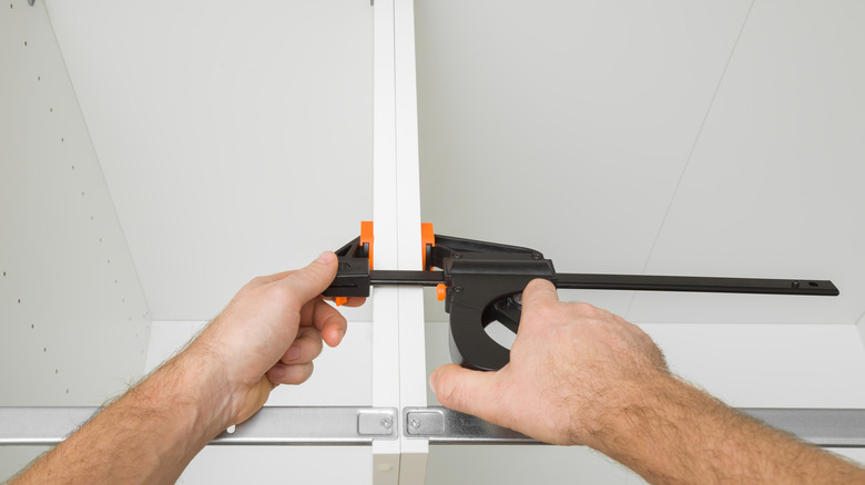 Aligning cabinets with ratcheting clamp