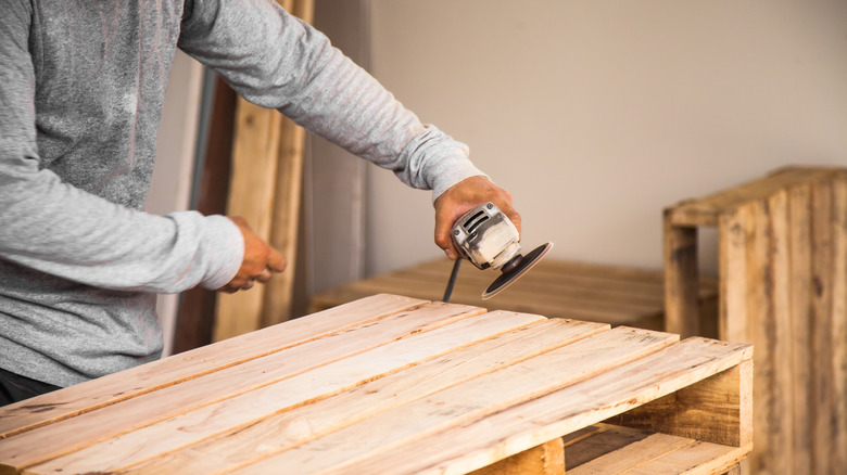 person using an electrical sander