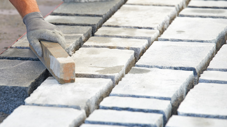 man laying paver stones 