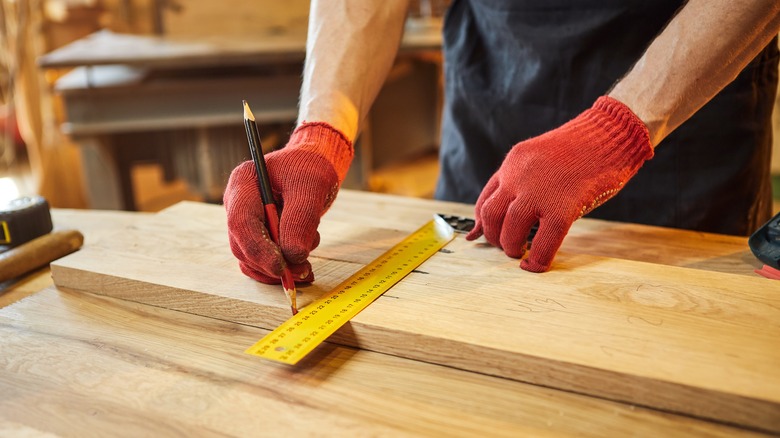 Woodworker marking wood for sawing