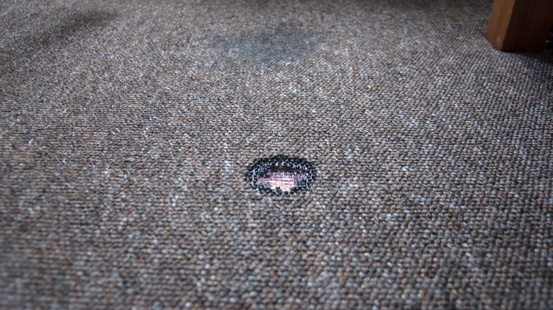 burn hole in dark carpet