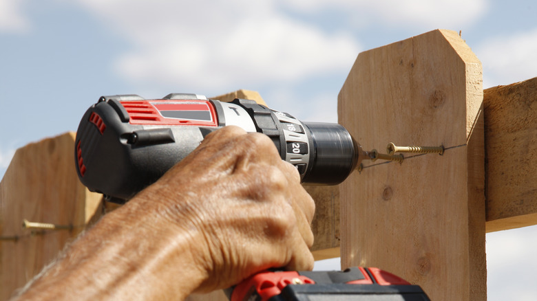 man building picket fence