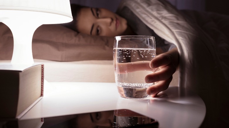 Lady sleeping with glass of water on bedside table