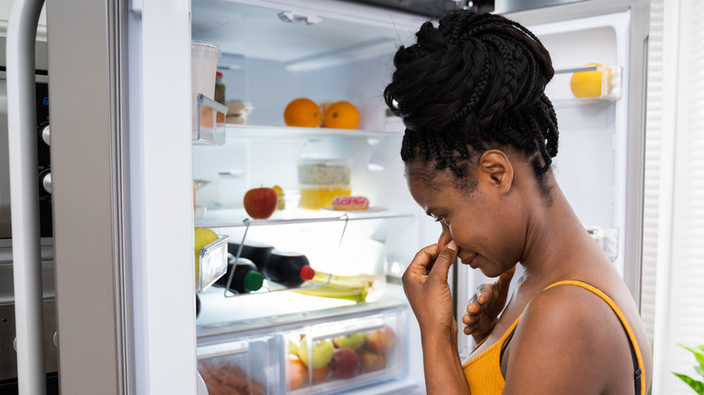 woman noticing unpleasant fridge smell