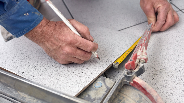 man marking tile