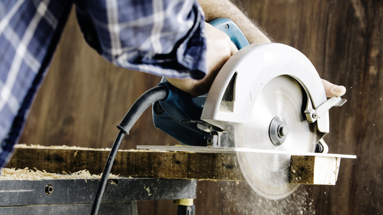 person cutting wood 