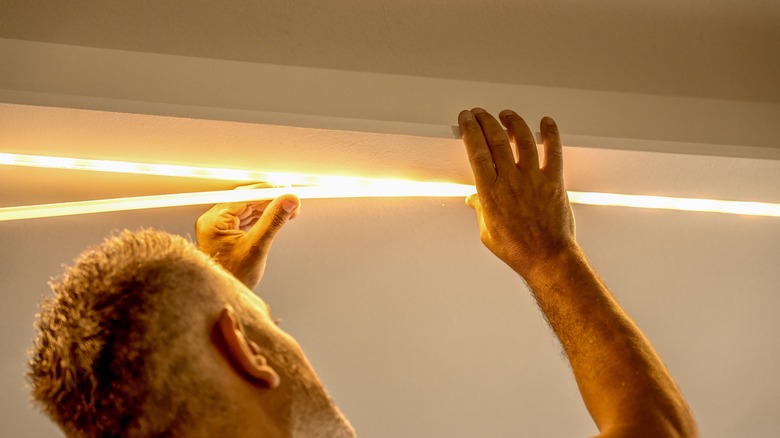 man installing LED strip lights 