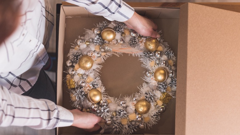Person putting wreath in box