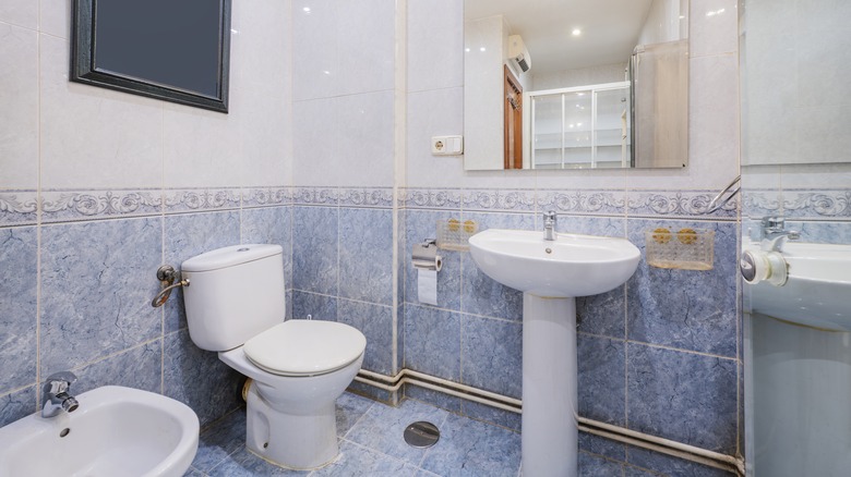 Bathroom with half-height blue tiles with listellos