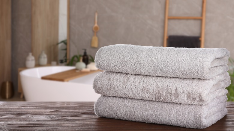 Clean towels on wooden table in a peaceful bathroom