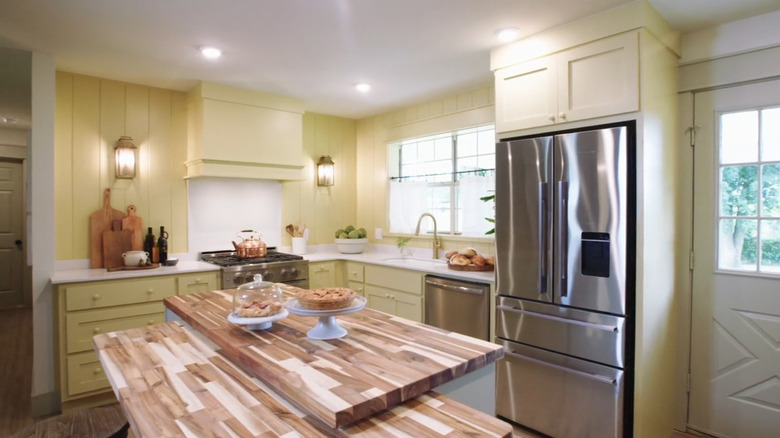 Kitchen with yellow wood paneling and cabinets on HGTV's "Fixer to Fabulous"