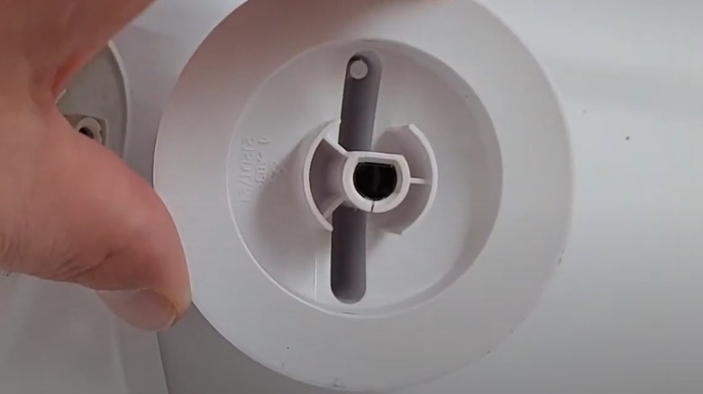 Person holding a cracked dryer knob after removing it