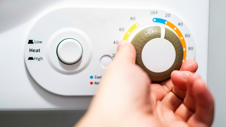 Person trying to turn the timer knob on a dryer