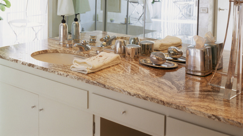 natural stone bathroom coutnertop with stainless steel and glass decor