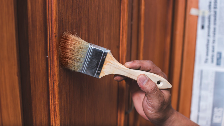 painting orange-toned wood stain on cabinets