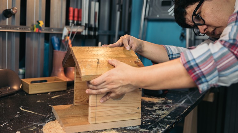 woman building birdhouse